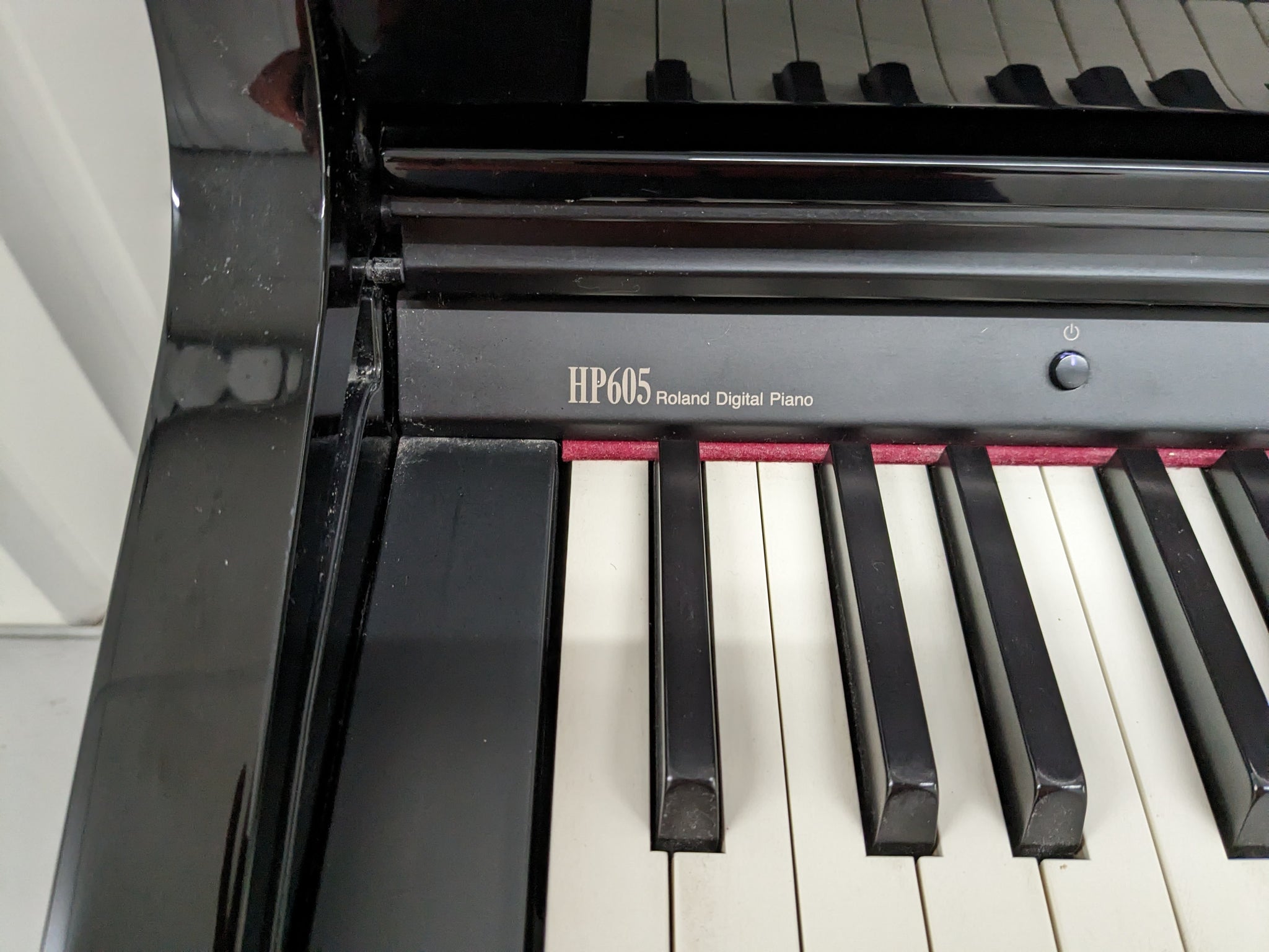 Roland HP605 digital piano and stool in glossy black polished