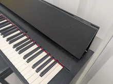 Load image into Gallery viewer, Roland F140R Digital Piano in satin black slim line space saver stock # 25303
